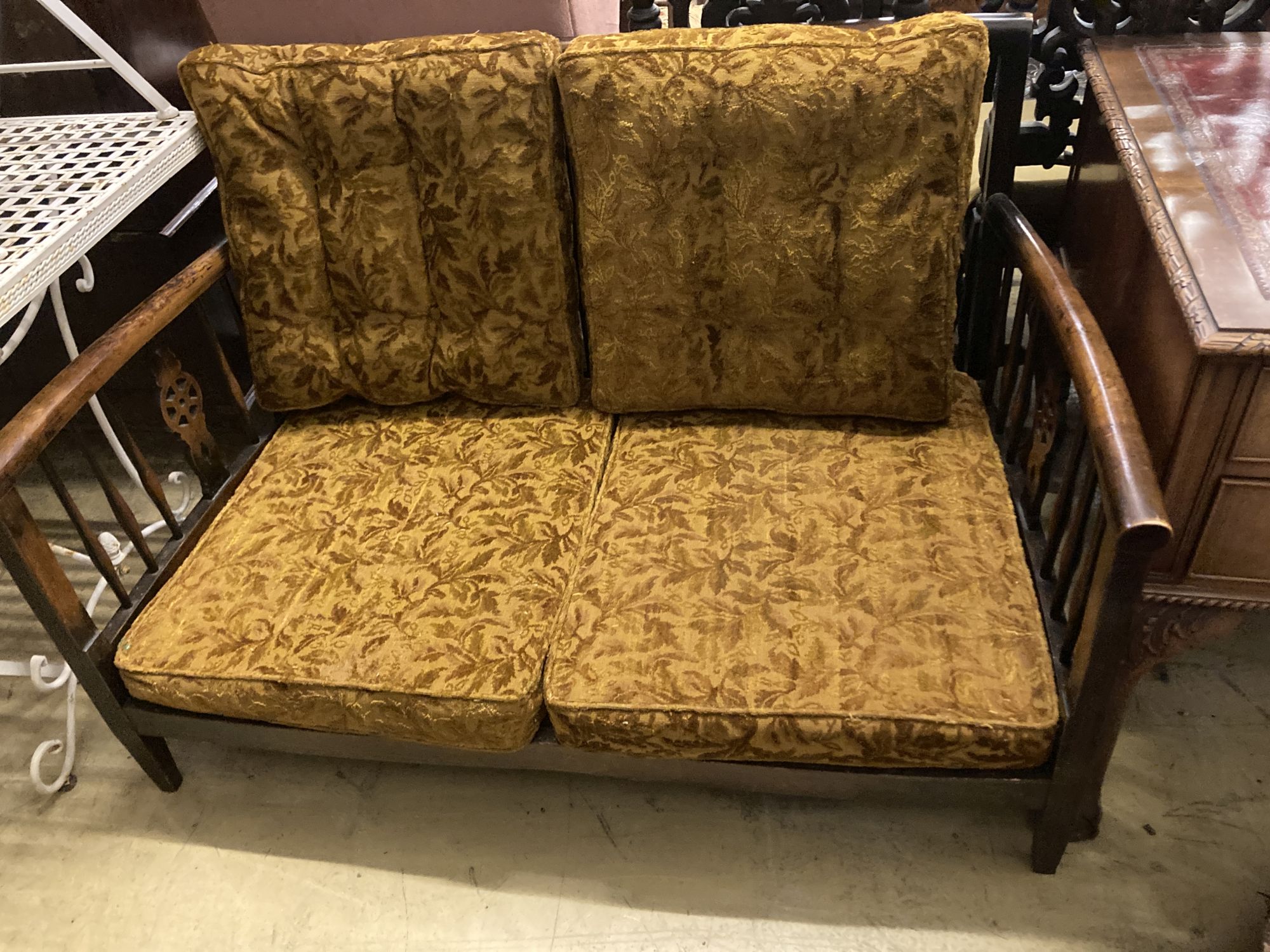 A 1920s beech wheelback settee, length 126cm, depth 74cm, height 80cm